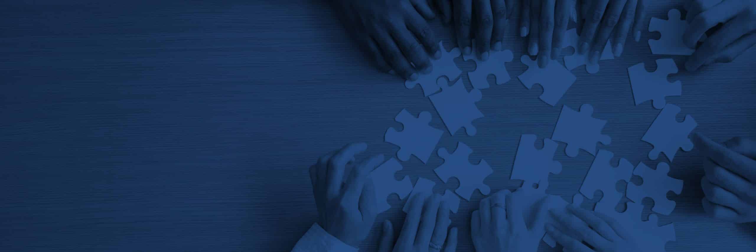 Many hands putting puzzle pieces together